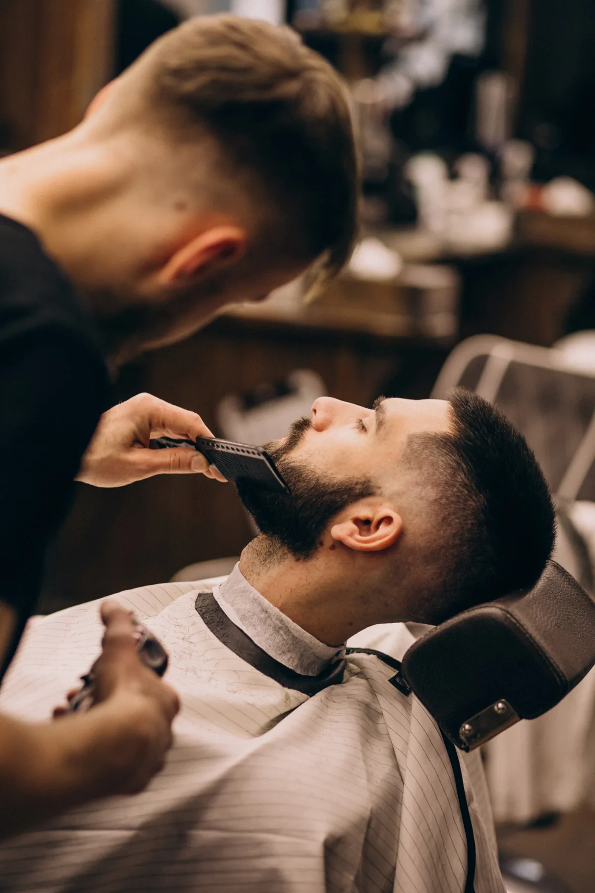 Barbeiro alinhando a barba do cliente